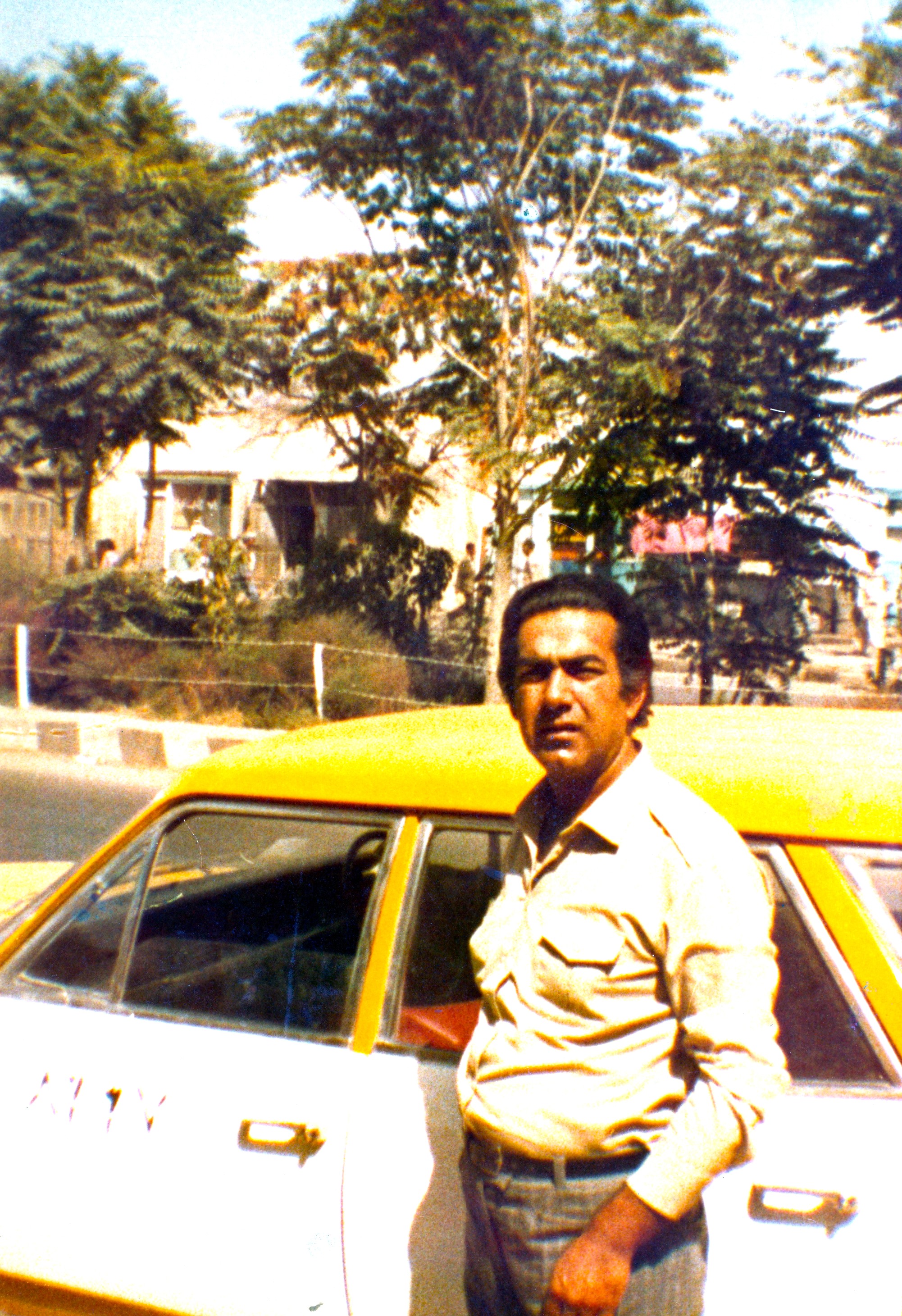 Mohammad Arif Sherdel beside his Opel taxi in Afghanistan